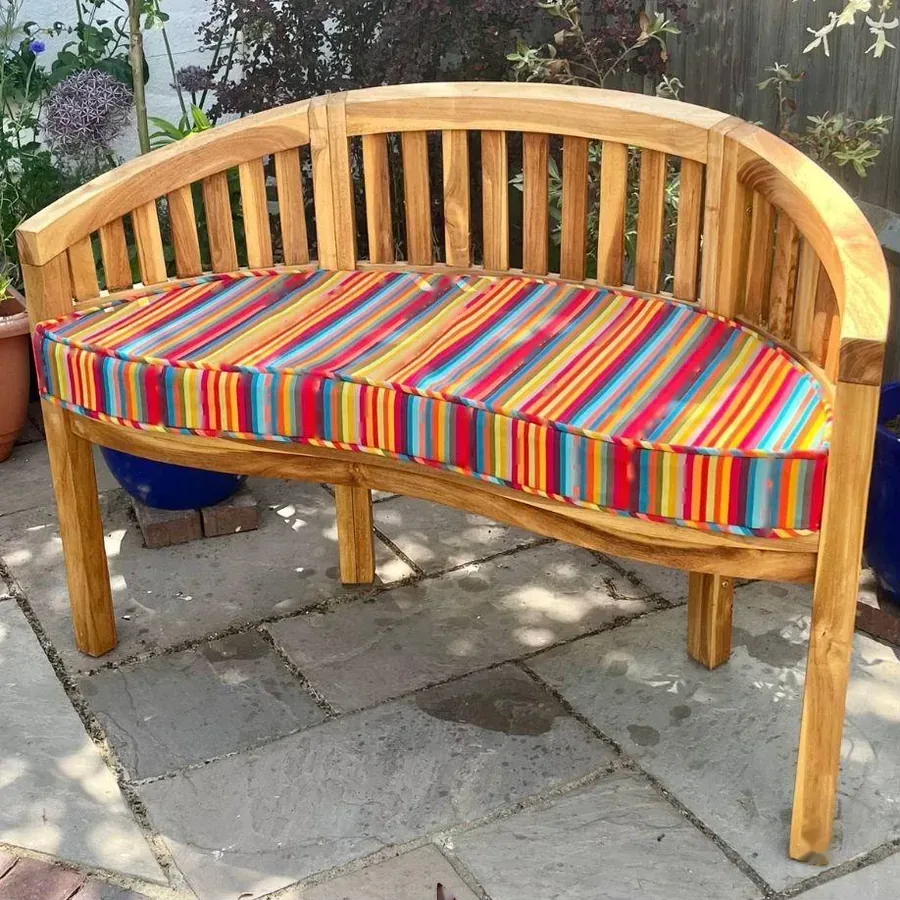 Shaped seat pad in a bright striped fabric on a garden bench